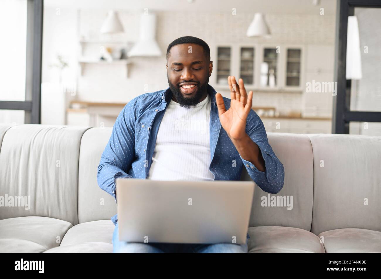Sorridente afroamericano che usa un computer portatile per videochiamare, un  ragazzo nero guarda la webcam e