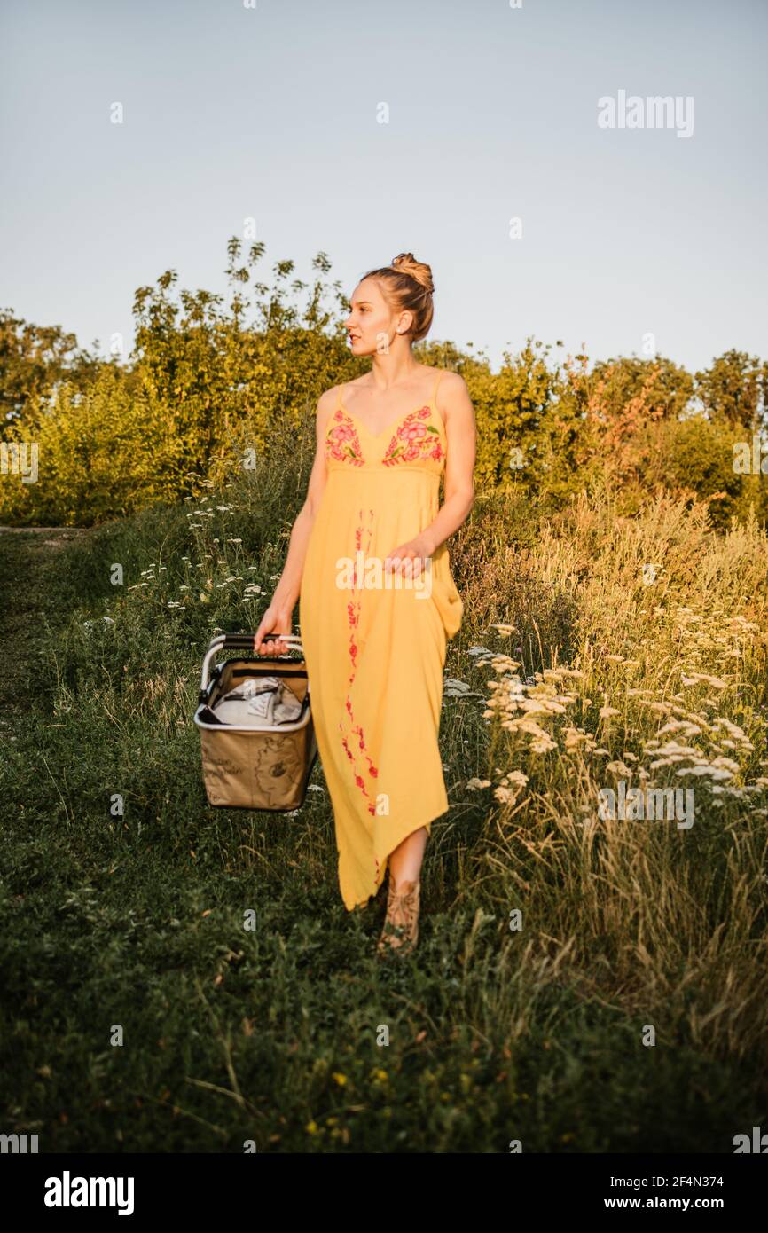 Vita senza sprechi, vita ecocompatibile, salvare la natura, vita lenta. Giovane bionda donna felice con sacchetto riutilizzabile in rete di cotone con cibo biologico sulla natura Foto Stock