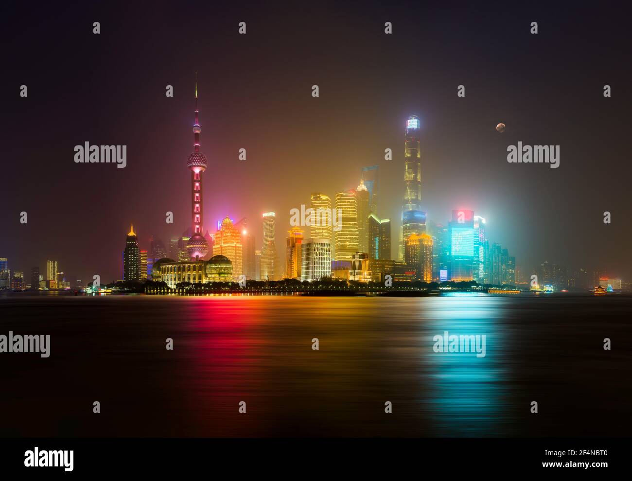 Shanghai Skyline di notte con luna e nebbia nel Aria - lunga esposizione sul fiume Huangpu Foto Stock
