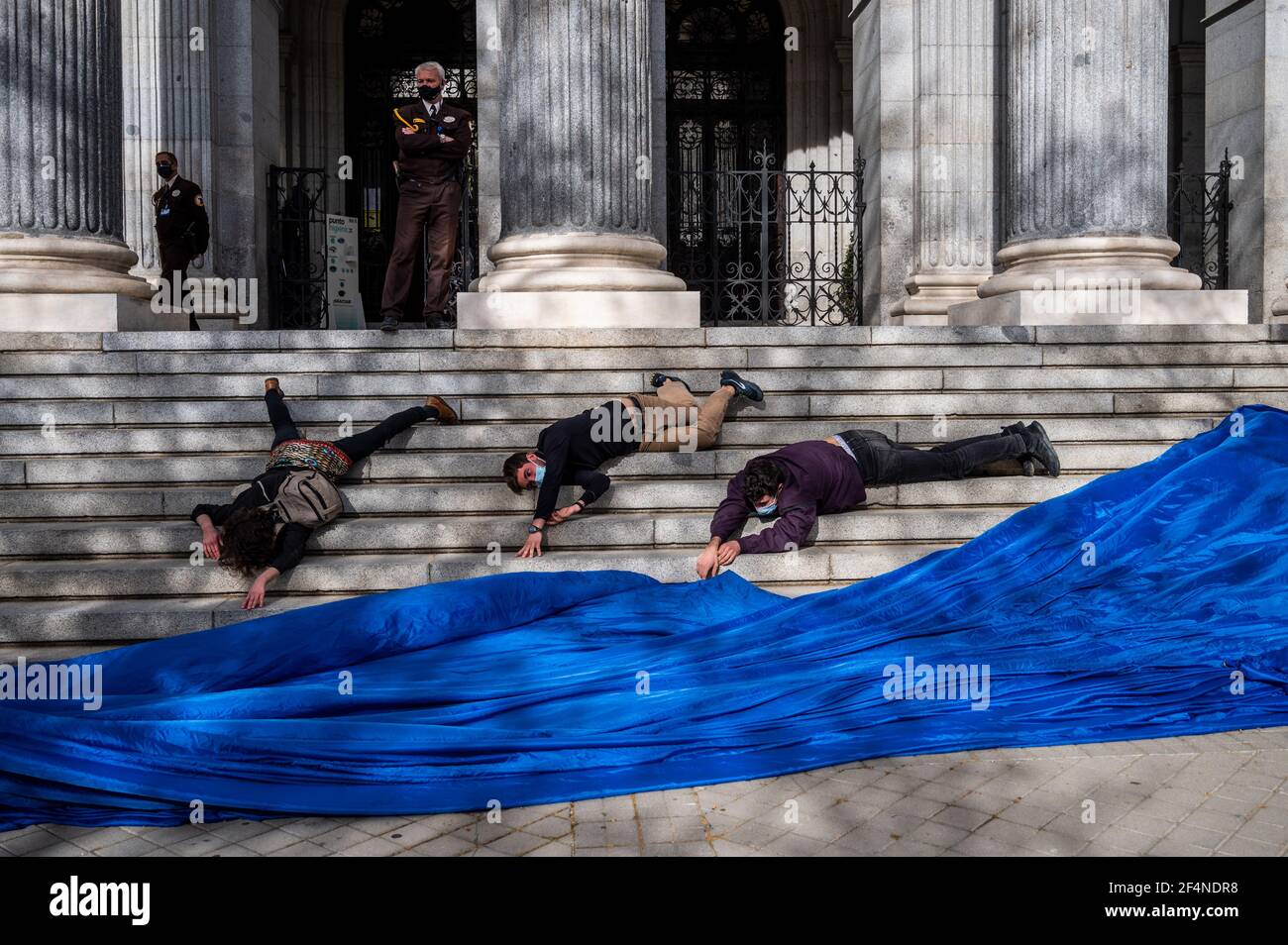 Madrid, Spagna. 22 marzo 2021. Attivisti ambientali dei gruppi 'Extinction Rebellion' (XR) e 'Friends of the Earth' che hanno eseguito un'azione di fronte all'edificio della Borsa di Madrid, in coincidenza con la Giornata Mondiale dell'acqua, denunciando il pericolo di speculazione con un bene fondamentale come l'acqua. Gli attivisti stanno avvertendo del precedente del prezzo dell'acqua californiano sul mercato Futures di Wall Street dallo scorso dicembre. Credit: Marcos del Mazo/Alamy Live News Foto Stock