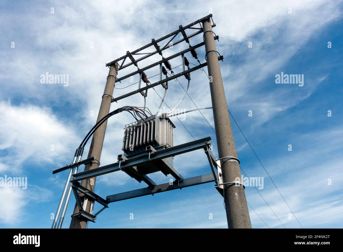 Trasformatore elettrico rurale contro cielo nuvoloso Foto Stock