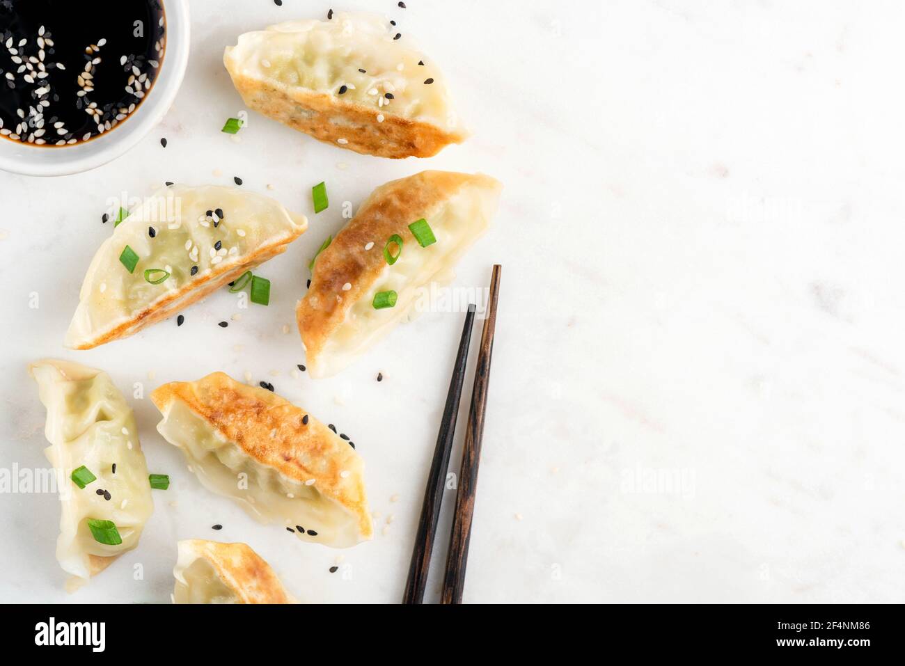 Gyoza fritto o Jiaozi su sfondo marmoreo, gnocchi cinesi con carne e verdure. Spazio di copia vista dall'alto Foto Stock