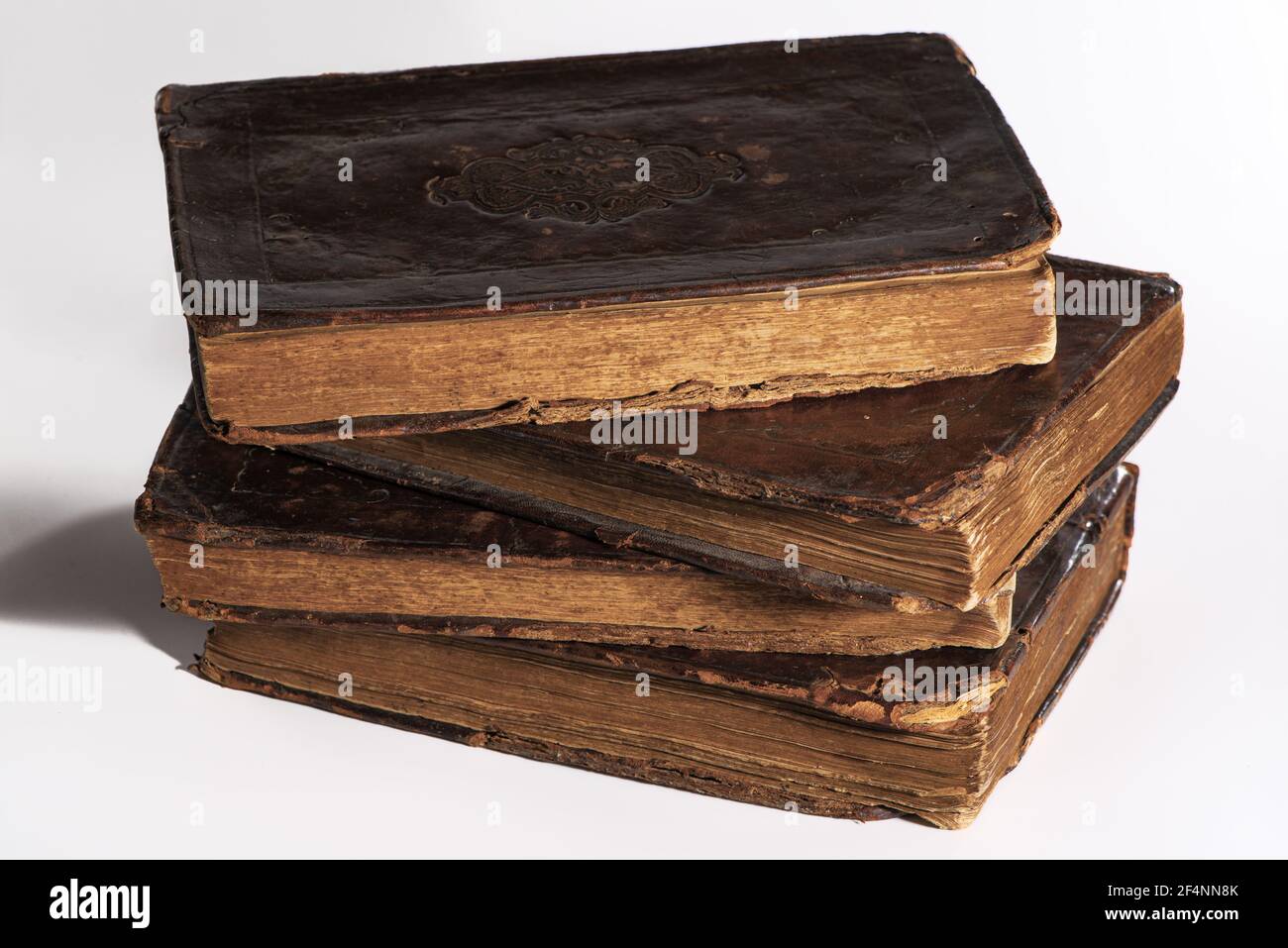 Pila di vecchi libri in pelle usurati isolati su sfondo bianco. Primo piano Foto Stock