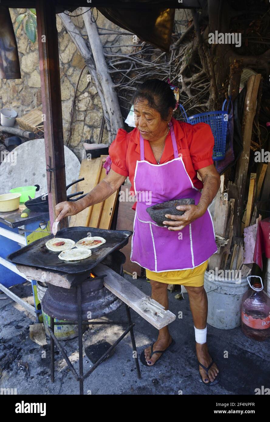 Donna fornitore di strada ispanica che fa i Sopes ad Acapulco, Messico. Foto Stock