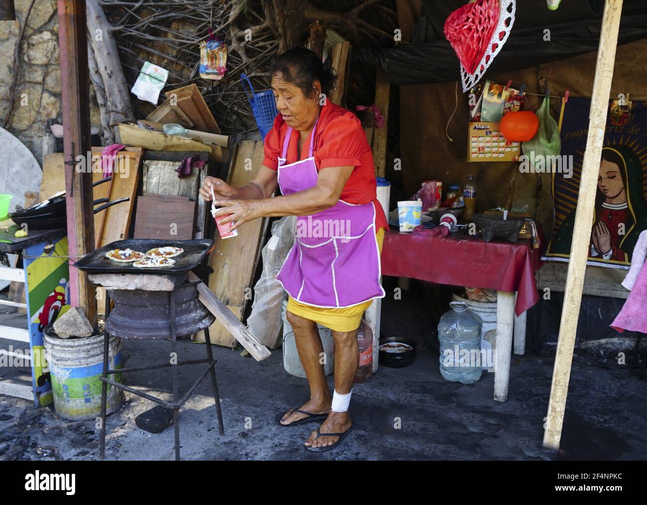 Donna fornitore di strada ispanica che fa i Sopes ad Acapulco, Messico. Foto Stock
