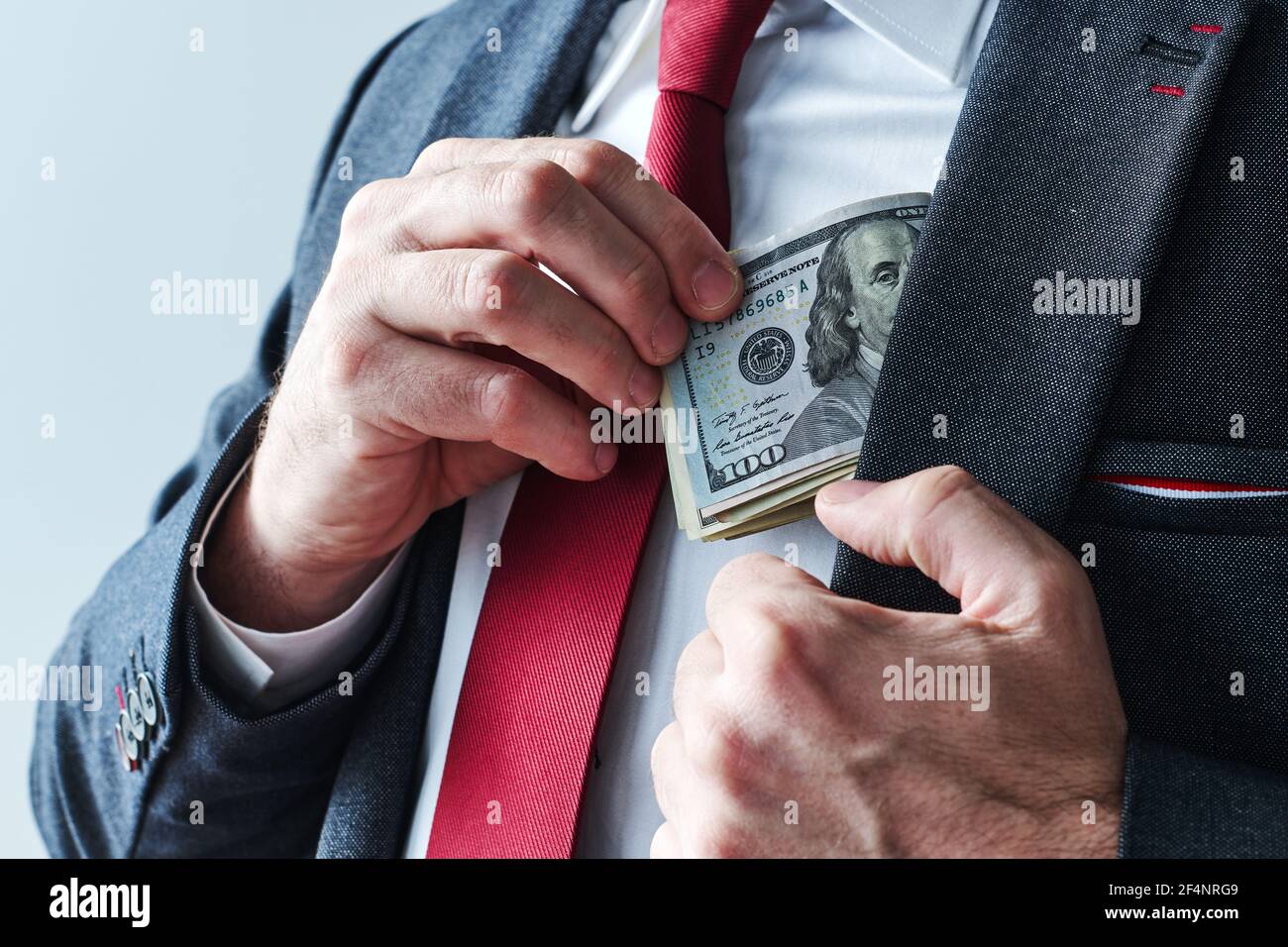 Uomo d'affari che prende i soldi in contanti del dollaro degli Stati Uniti dalla sua tasca del vestito, primo piano di uomo d'affari elegante Foto Stock