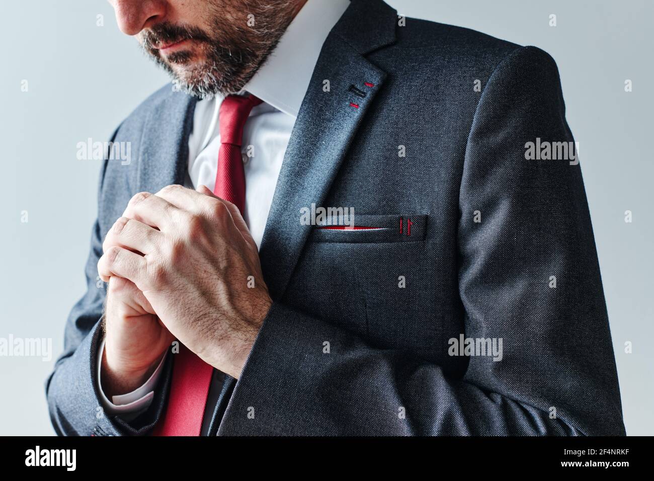 Uomo d'affari interessato con le mani piegate per il concetto di linguaggio del corpo di anticipazione Foto Stock