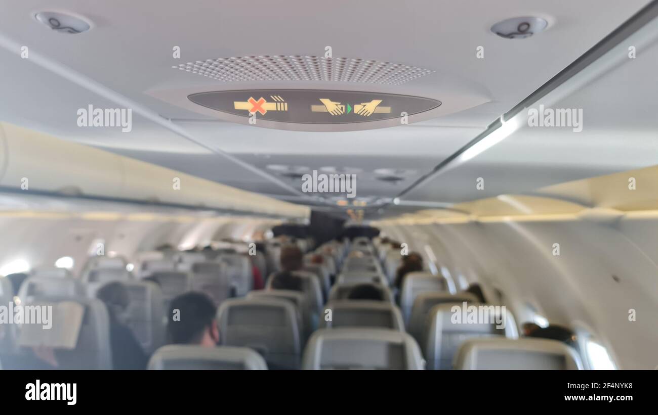 Allacciare la cintura di sicurezza e il cartello di divieto di fumo su un aereo passeggeri Foto Stock