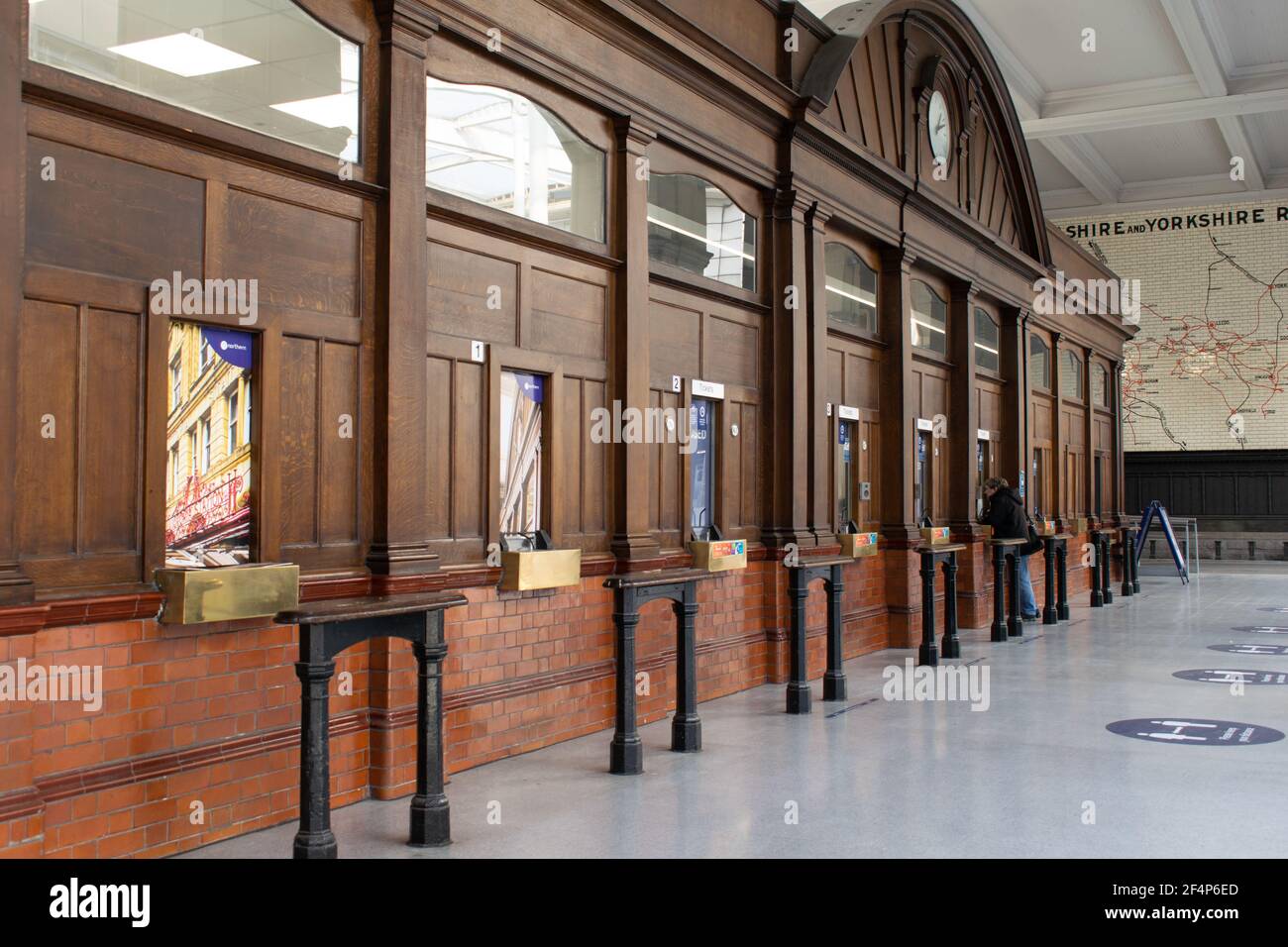 La biglietteria della stazione ferroviaria Victoria di Manchester, con facciata in legno, con un solo passeggero al finestrino durante il blocco nazionale in Inghilterra. Foto Stock