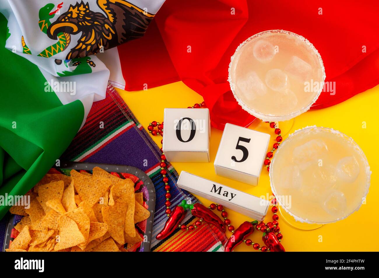 Festa messicana fiesta e Cinco de Mayo tema di concetto con blocco calendario fissato il 5 maggio, jalapeno pepe perline collana, tappeto tradizionale o serape, tw Foto Stock