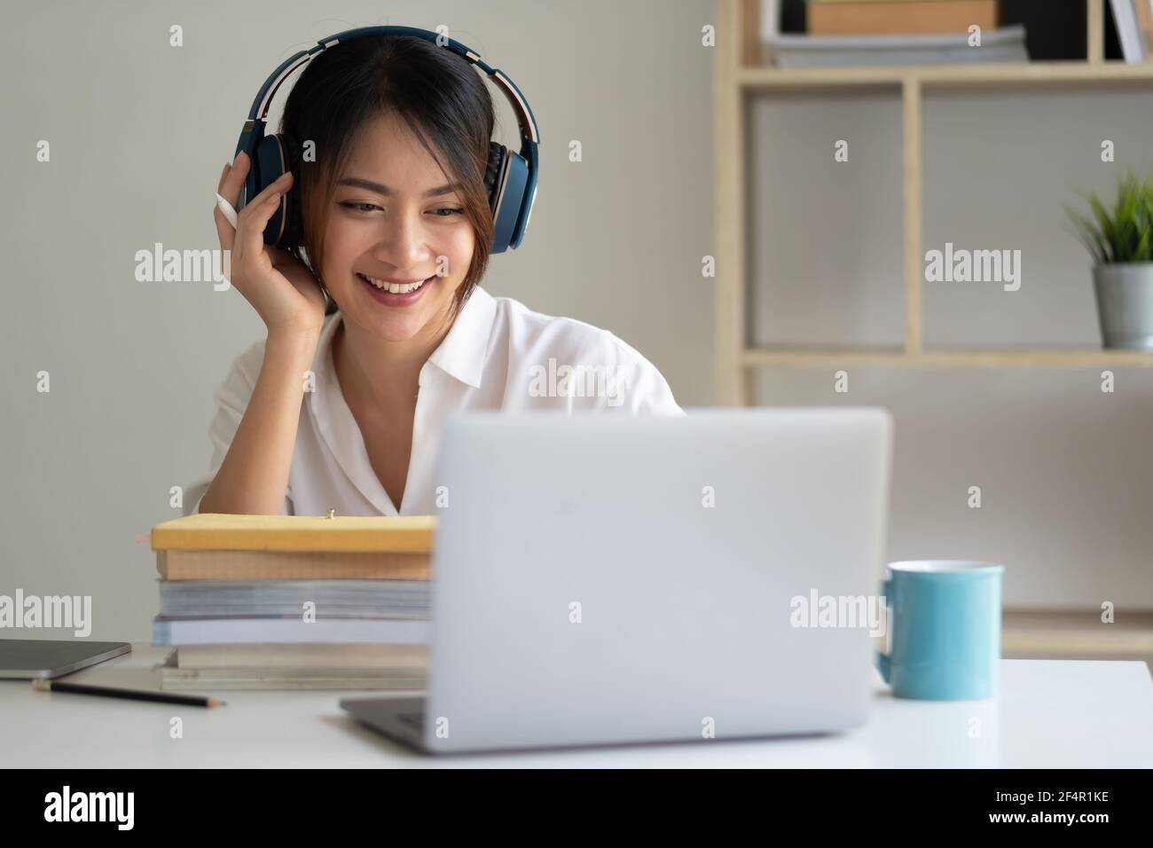 Donna asiatica che indossa le cuffie studiare online guardare il webinar podcast sul laptop ascoltare apprendimento corso di formazione conference call, elearning Foto Stock