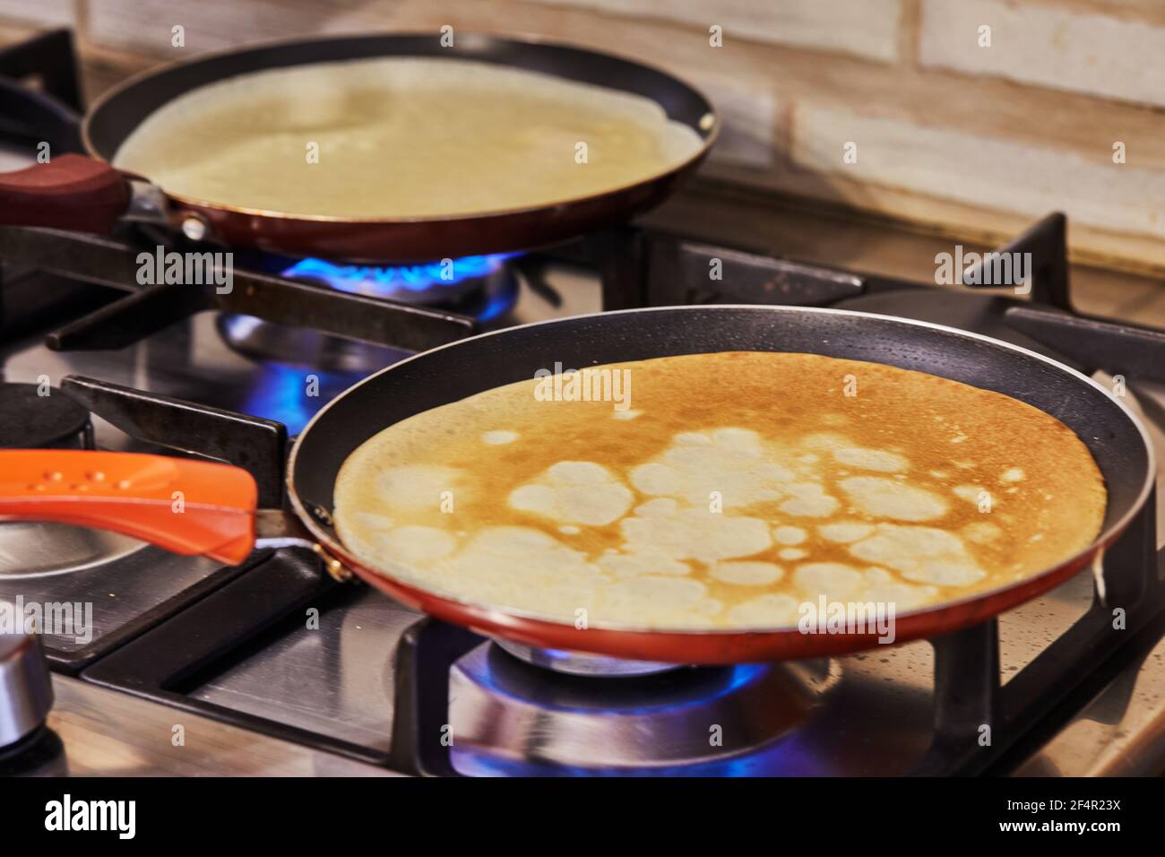 Le frittelle vengono fritte in padelle su un forno a gas. Ricetta passo per passo. Foto Stock