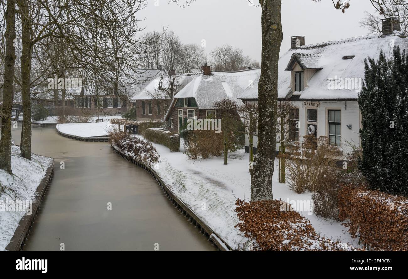 Giethoorn, Paesi Bassi - 7 febbraio 2021: La pittoresca città di Giethoorn con ghiaccio sui canali e neve sui tetti delle fattorie. Foto Stock