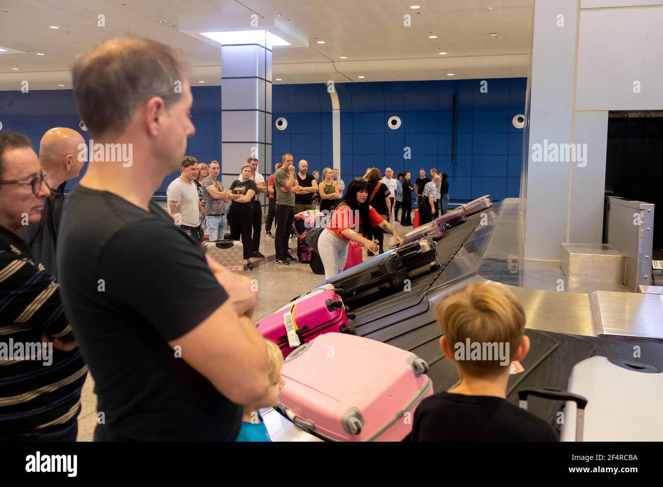 La gente sta aspettando i propri bagagli dopo l'atterraggio. Foto Stock