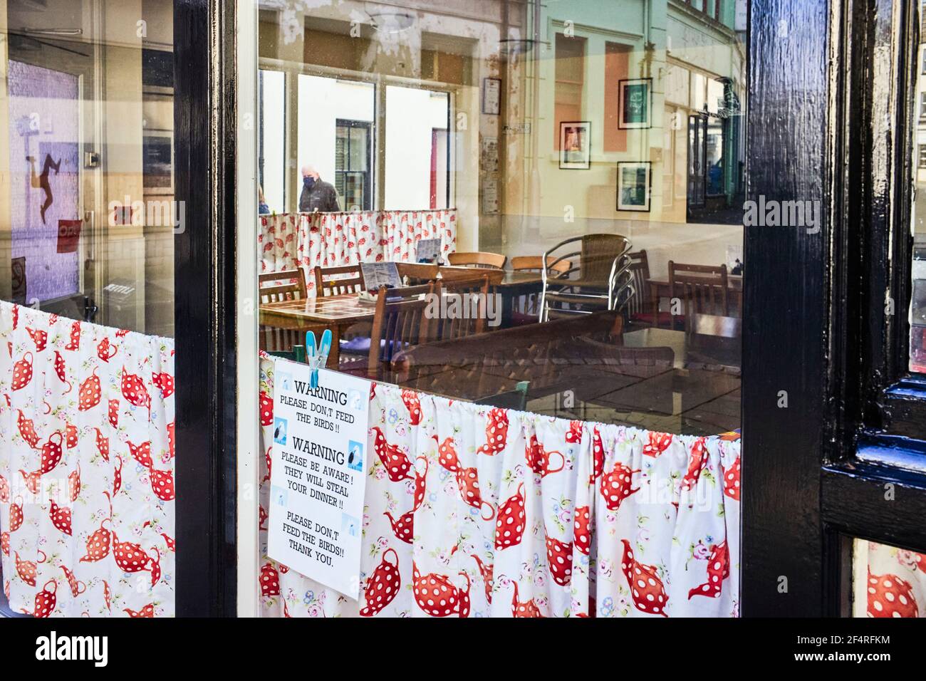 Caffè vuoto in Micheal Street, Peel, Isle of Man con finestra di accesso per avvisare che non si nutrono gabbie Foto Stock