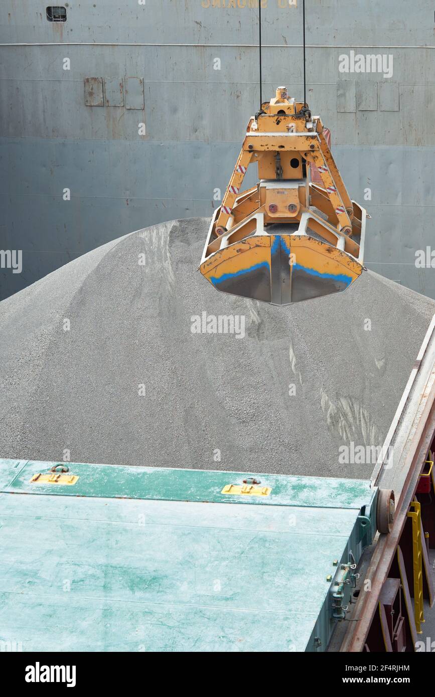 Carico e scarico della bauxite di carico sfuso su nave portarinfuse utilizzando benna o benna a benna. Foto Stock