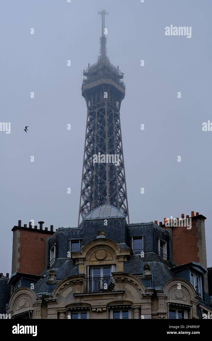 Edifici residenziali parigini e la cima della torre Eiffel in una giornata piovosa Foto Stock