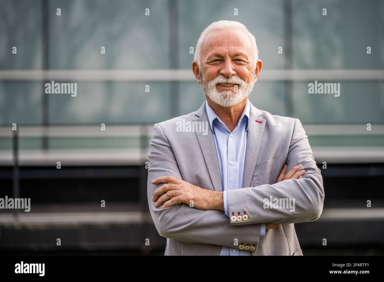 Ritratto esterno di uomo d'affari senior di fronte all'edificio aziendale. Foto Stock