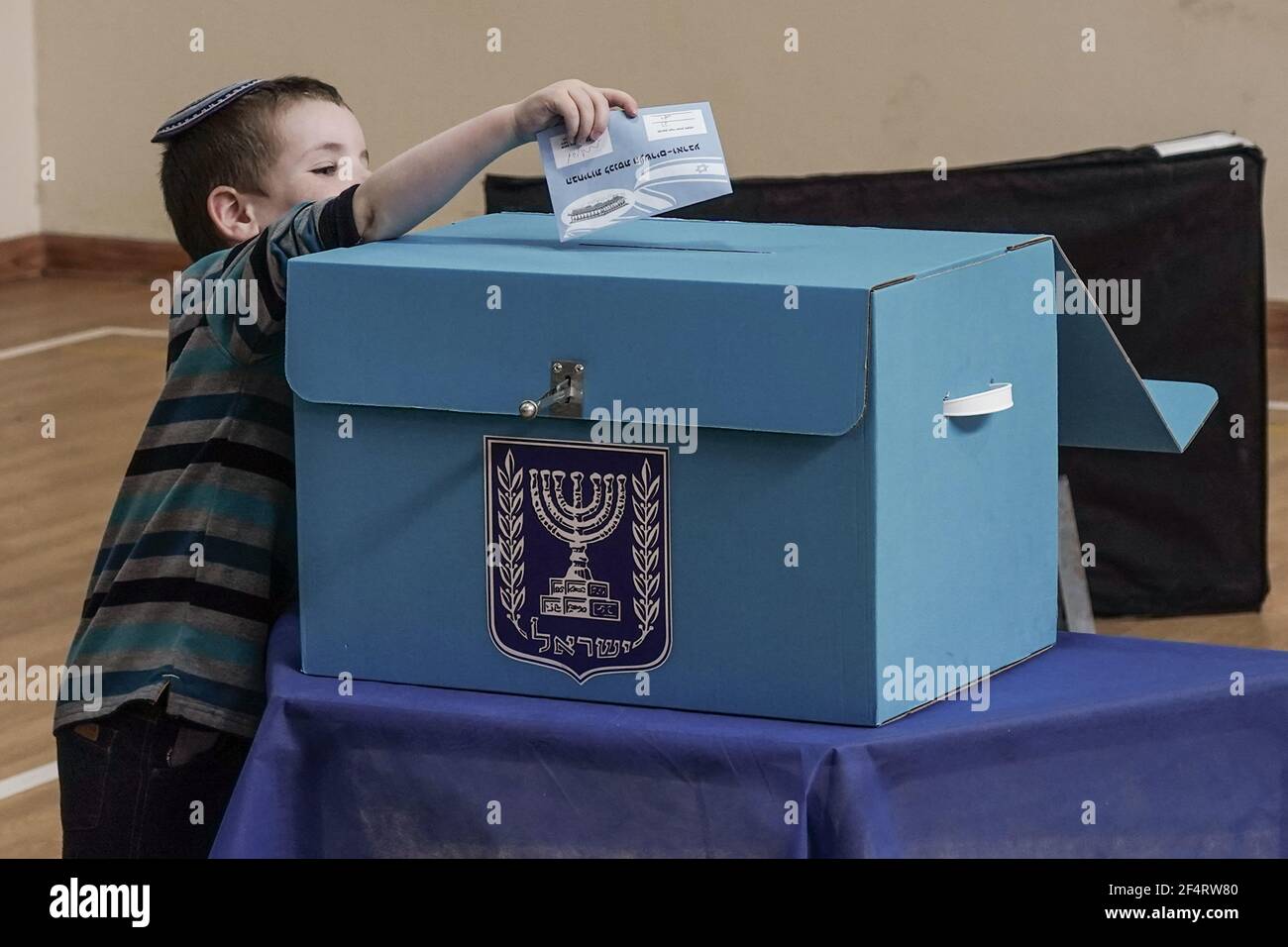 Gerusalemme, Israele. 23 marzo 2021. Gli elettori inseriscono i loro voti in una casella di voto nelle quattro elezioni nazionali in Israele in due anni per la Knesset, il Parlamento israeliano. 15,000 seggi sono operati a livello nazionale, il 30% in più rispetto al 2020, inclusi in ogni vita assistita per le strutture anziane, all'interno dei reparti ospedalieri di Coronavirus e in quarantena drive through stazioni di voto per quelli testati positivi per COVID-19 o sotto quarantena obbligatoria. Credit: NIR Alon/Alamy Live News Foto Stock