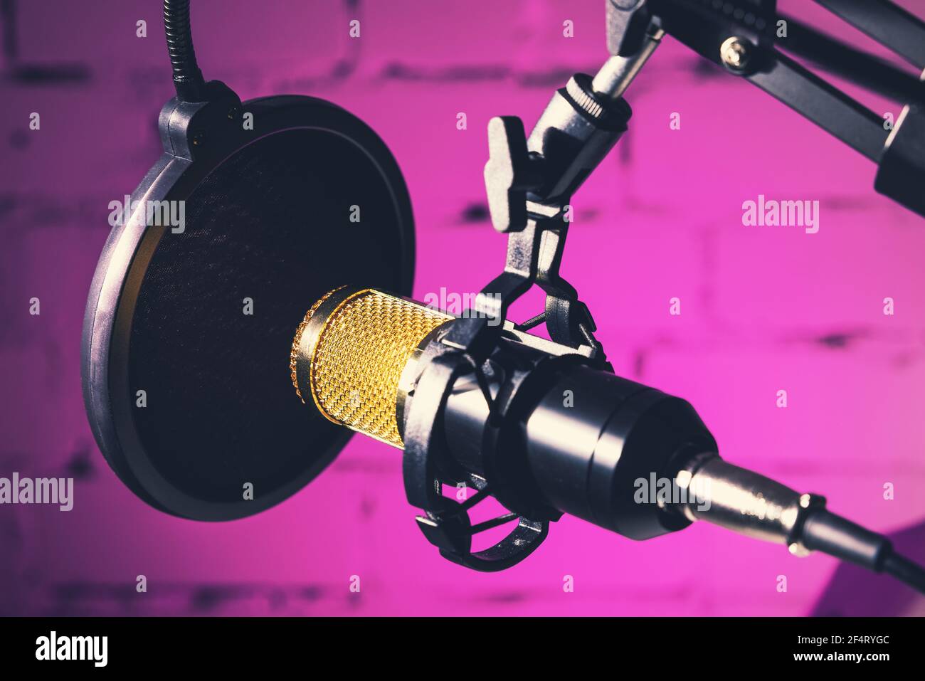 microfono professionale da studio su sfondo rosa neon Foto Stock