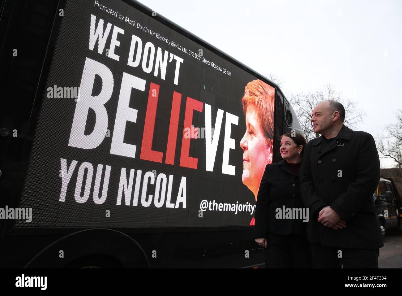 Mark e Mary Devlin esamineranno un tabellone mobile che hanno organizzato e che dice "non crediamo Nicola" mentre guida attraverso la circoscrizione del primo ministro Nicola Sturgeon nella zona di Govanhill a Glasgow come parte della campagna ResignSturgeon della maggioranza nella corsa alle elezioni scozzesi del mese di maggio 6. Data immagine: Martedì 23 marzo 2021. Foto Stock