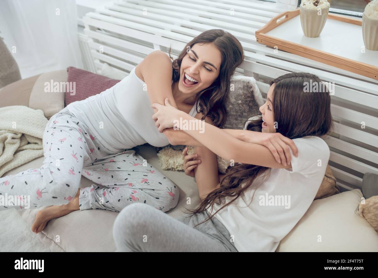 Mamma e figlia combattono come scherzo sul letto Foto Stock