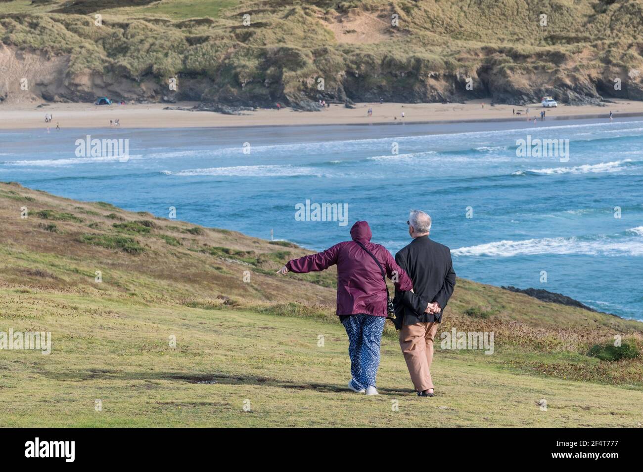 Una coppia matura in una vacanza di staycation godendosi una passeggiata insieme lungo il punto orientale di Pentire che si affaccia sulla spiaggia di Crantock a Newquay in Cornovaglia. Foto Stock