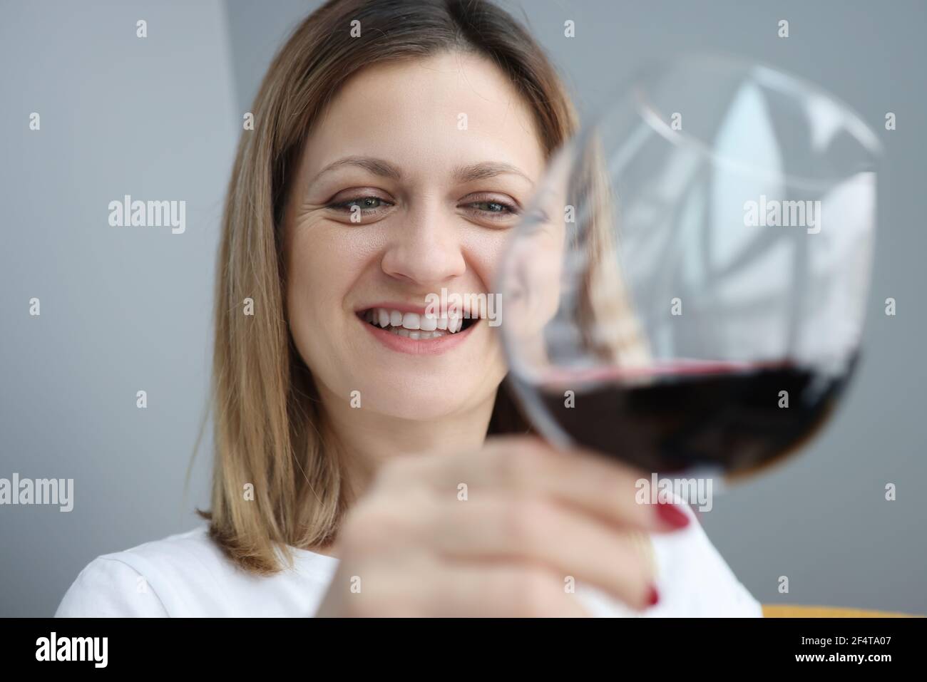 Ritratto di giovane donna con bicchiere di vino rosso in la sua mano Foto Stock