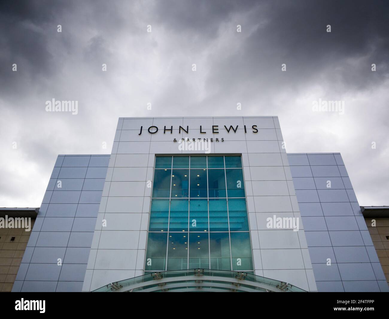 L'entrata al negozio John Lewis & Partners sotto le nuvole scure al Mall Shopping Center, Cribbs Causeway, Gloucestershire vicino Bristol, Inghilterra. Foto Stock
