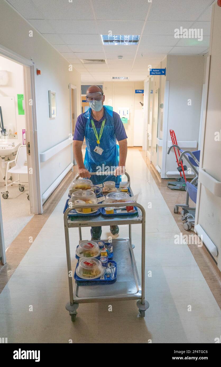 Un volontario della Carità Imperiale, Michael amiss, spinge un carrello per la consegna dei pasti su un reparto dell'ospedale di Charing Cross come parte del charityÕs covid crisi Foto Stock
