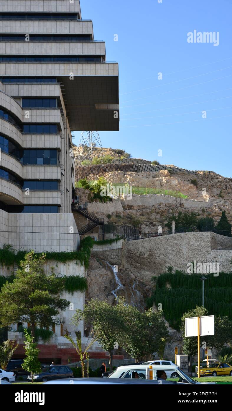 Shiraz, Iran: Lo spettacolare edificio moderno dello Shiraz Hotel, con poco flusso che scorre lungo la roccia accanto ad esso. Dettaglio. Foto Stock