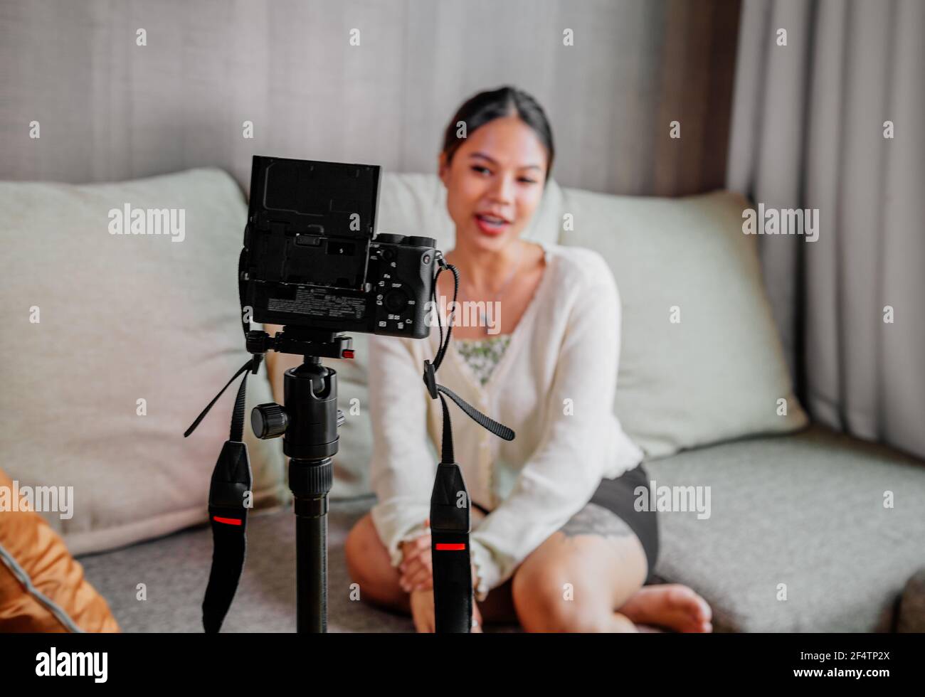 Blogger asiatico, podcaster o vlogger guardando la fotocamera e parlando di riprese video con la tecnologia. Persone influenti sui social media o produttori di contenuti Foto Stock