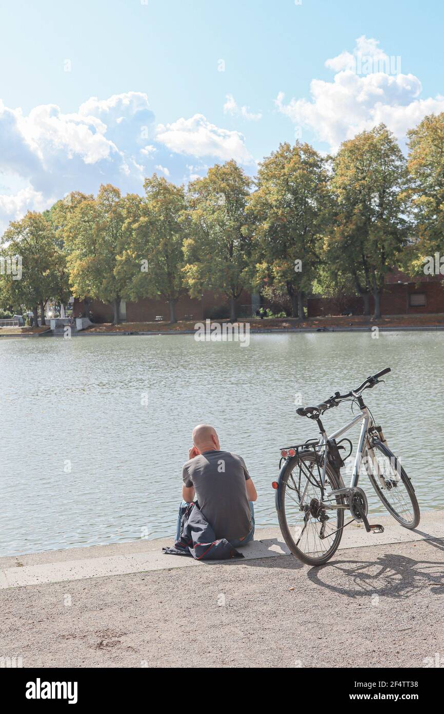 Bellissimo Parco Hiroshima-Nagasaki durante la primavera, vista sul lago con un uomo in bicicletta, Colonia, Germania Foto Stock