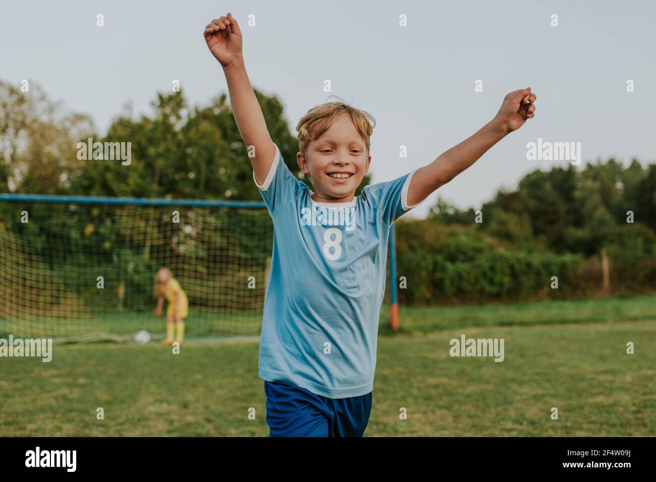 Bambini che giocano a calcio all'aperto sul campo. Felice giovane ragazzo che segna l'obiettivo durante la partita di calcio amatoriale. Foto Stock