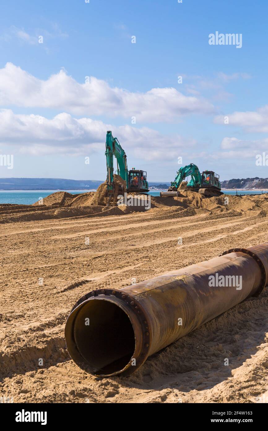 Scavatori spostare la sabbia ad Alum Chine, Bournemouth spiaggia per il rifornimento di spiaggia di lavoro a Bournemouth, Dorset Regno Unito in marzo Foto Stock