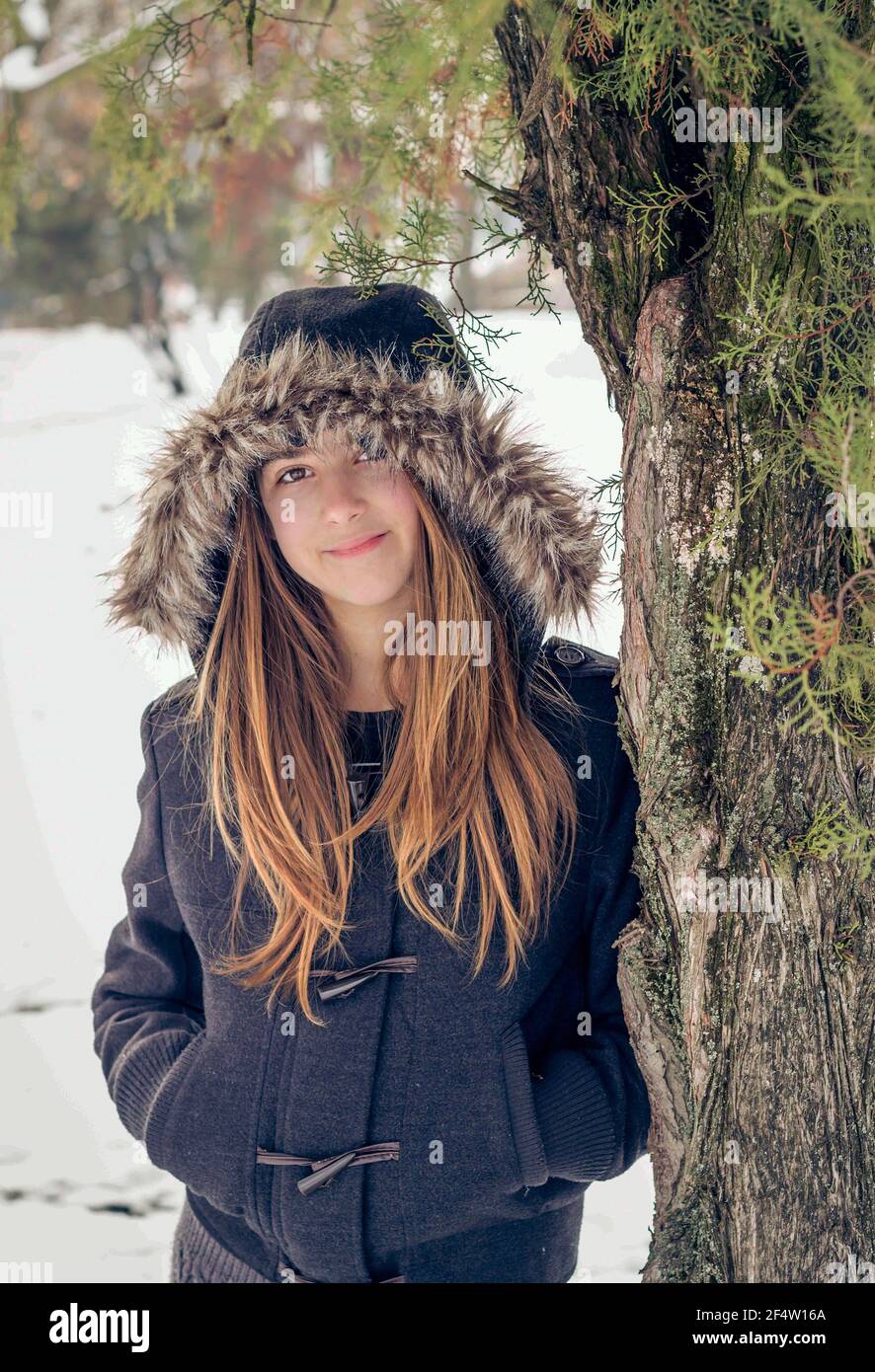 Foto all'aperto di una giovane ragazza con giacca invernale in pelliccia Foto Stock