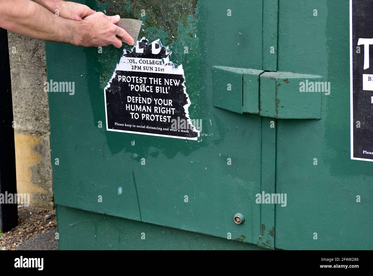Uomo occupato rottamare il poster "uccidere la fattura" bloccato Box di manifestanti in disordine violento nel centro di Bristol nei prossimi giorni pulire Foto Stock