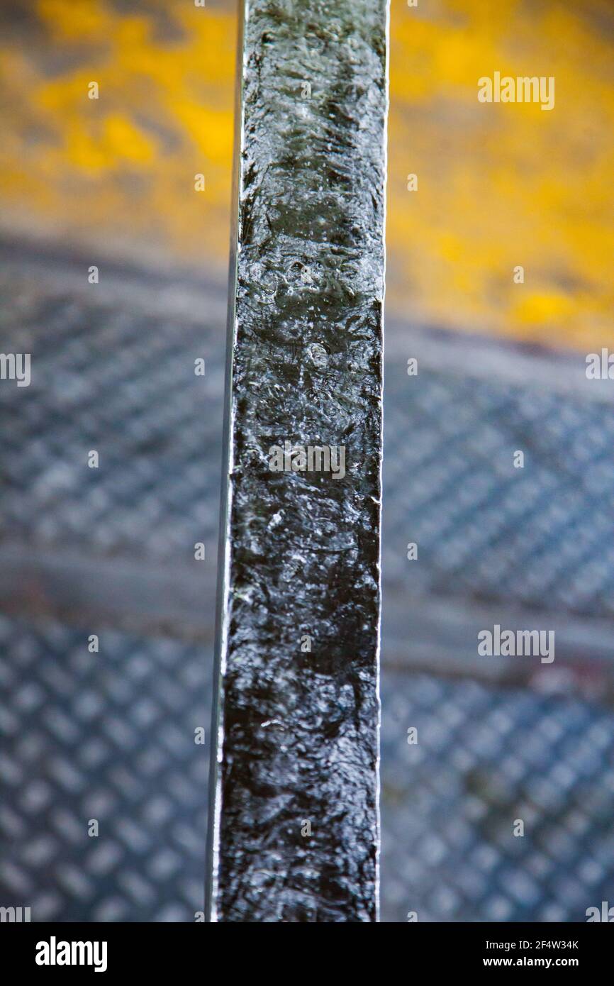 Predisposizione per il rivestimento della vergella in alluminio. Superficie lucida di metallo. Pavimento di fabbrica e sfondo della parete. Foto Stock