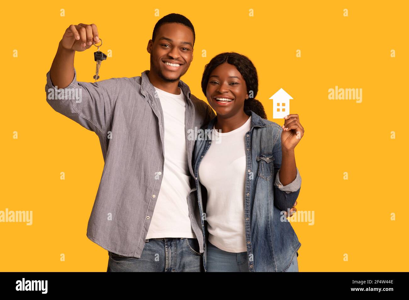Nuovi proprietari di casa. Felice coppia afroamericana che tiene la casa di carta e le chiavi Foto Stock