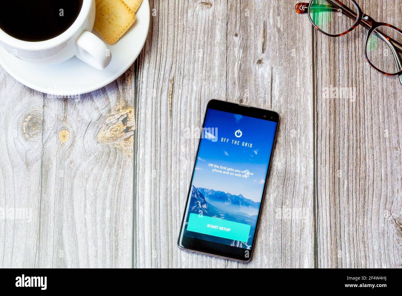 Un telefono cellulare o un telefono cellulare posato su un legno Tavolo con l'app Off the Grid aperta sullo schermo Foto Stock
