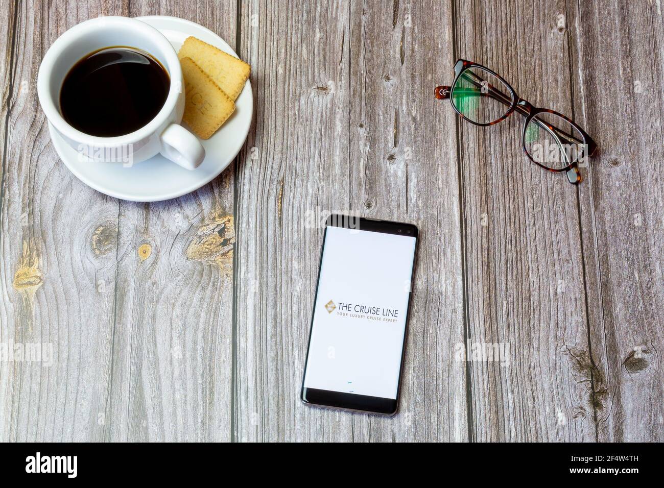 Un telefono cellulare o un telefono cellulare posato su un legno Tavolo con l'app Cruise line aperta sullo schermo Foto Stock