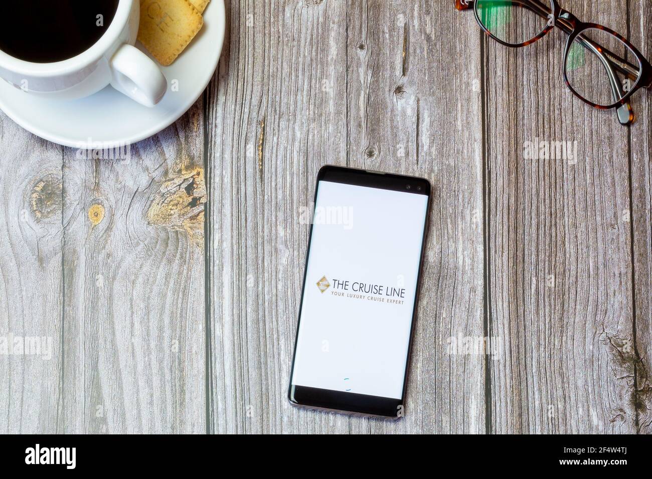 Un telefono cellulare o un telefono cellulare posato su un legno Tavolo con l'app Cruise line aperta sullo schermo Foto Stock