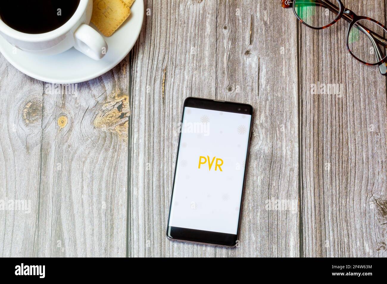 Un telefono cellulare o un telefono cellulare posato su un legno Tavolo con l'app PVR Cinema aperta sullo schermo Foto Stock