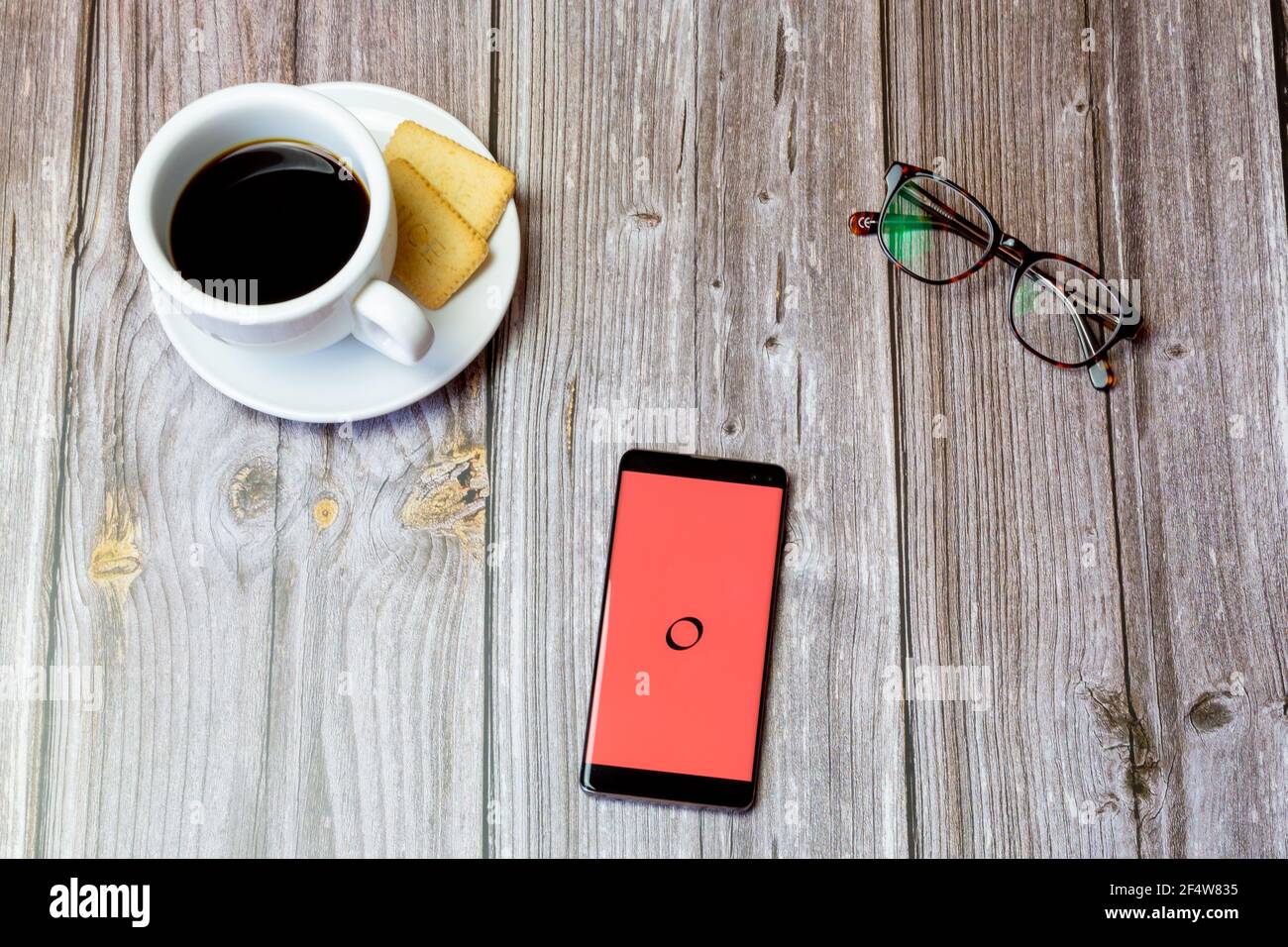 Un telefono cellulare o un telefono cellulare posato su un legno tabella con l'app trasferimento di denaro galassia aperta su schermo Foto Stock