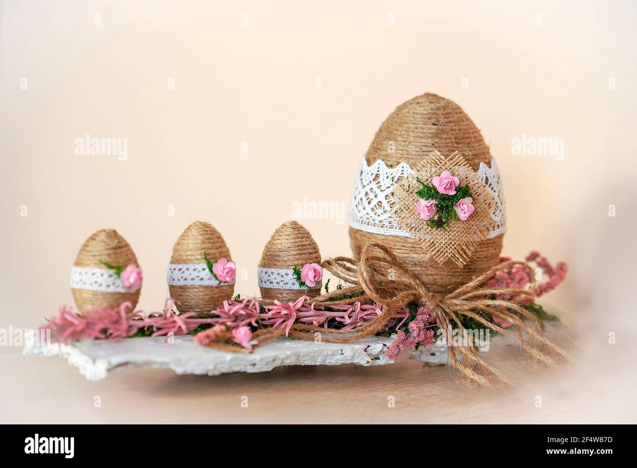 Decorazione pasquale - uova in cesti fatti di spago di canapa, decorate con  bellissimi fiori e pizzo tovaglia. Composizione rustica. Spazio di copia  Foto stock - Alamy