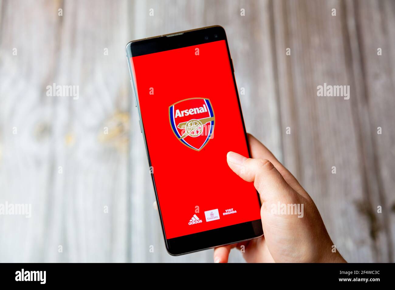 Un telefono cellulare o un telefono cellulare in attesa in un Mano con l'app Arsenal aperta sullo schermo Foto Stock