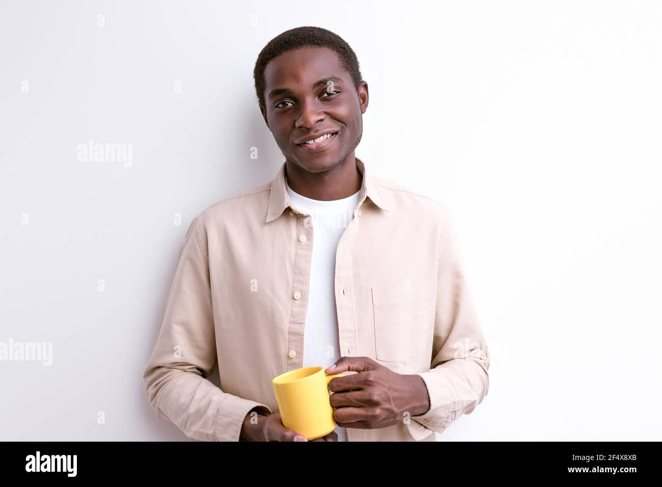 Black Man in abbigliamento casual in posa a Camera Holding Yellow
