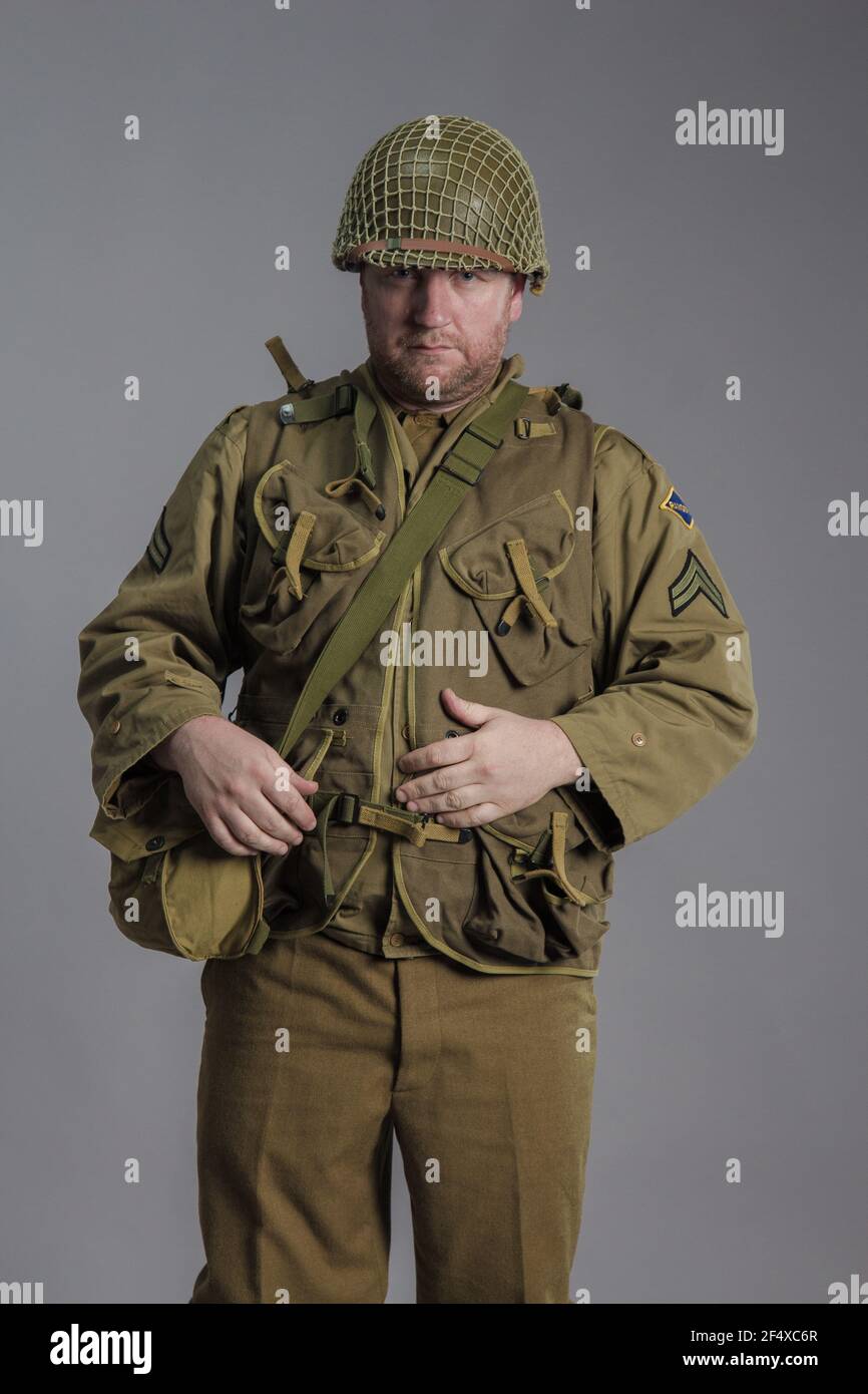 L'uomo è un attore nell'uniforme militare di un ranger americano,  indossando un casco, il periodo della seconda guerra mondiale è in posa su  uno sfondo grigio Foto stock - Alamy
