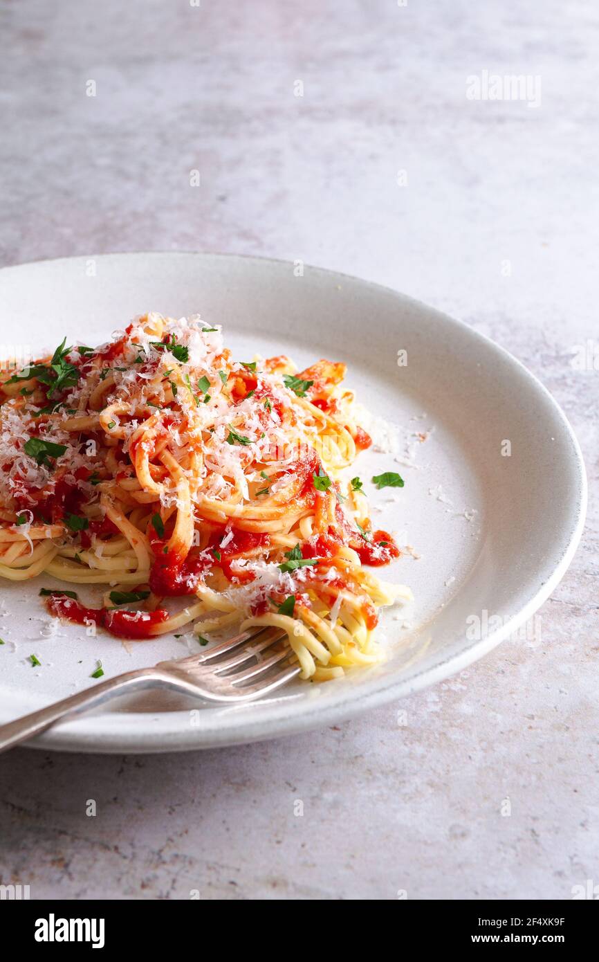 Piatto di spaghetti freschi con salsa di pomodoro, parmigiano e prezzemolo tritato. Foto Stock