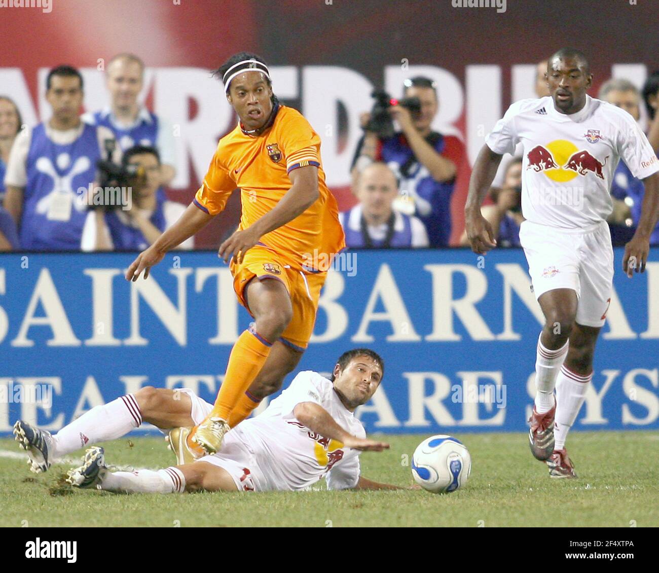 Ronaldinho cerca di saltare lontano da Dema Kovalenko. Il FC Barcelona ha demolito la Red Bull New York 4-1 davanti a oltre 79,000 tifosi nello stadio Giants, East R. Foto Stock